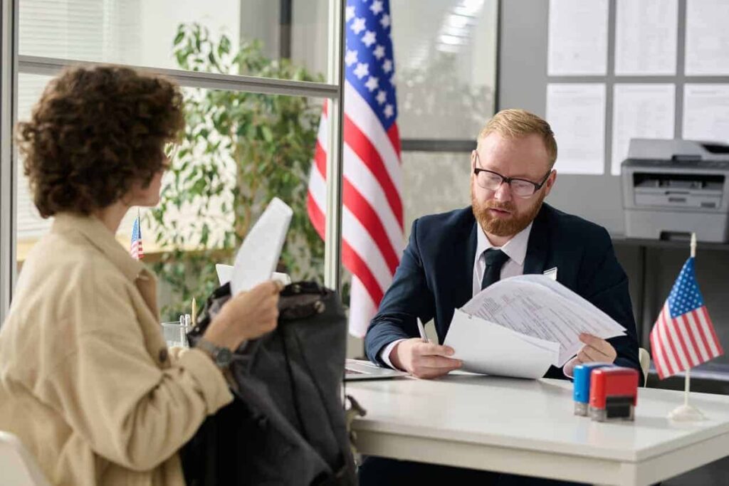 Consular officer reviewing documents during a US visa interview at the embassy
