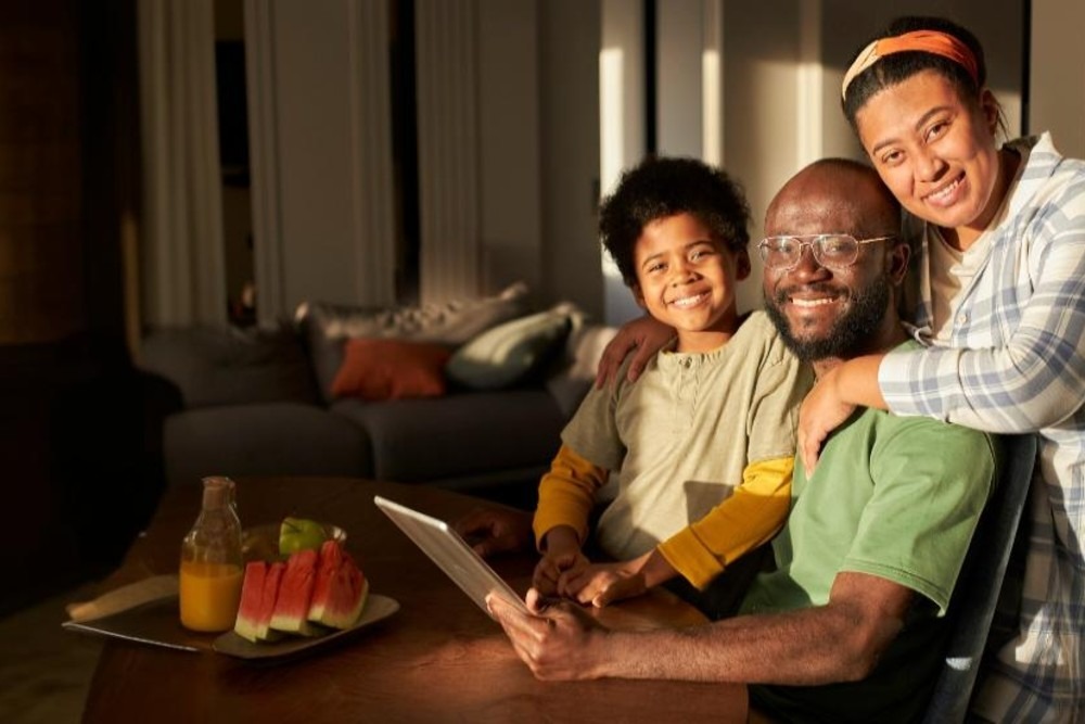 A Black family at home reviewing US immigration paperwork, illustrating spouse and family immigration planning.